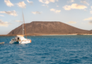 Catamarano ormeggiato con le vele riposte e il sole che si riflette sull'acqua